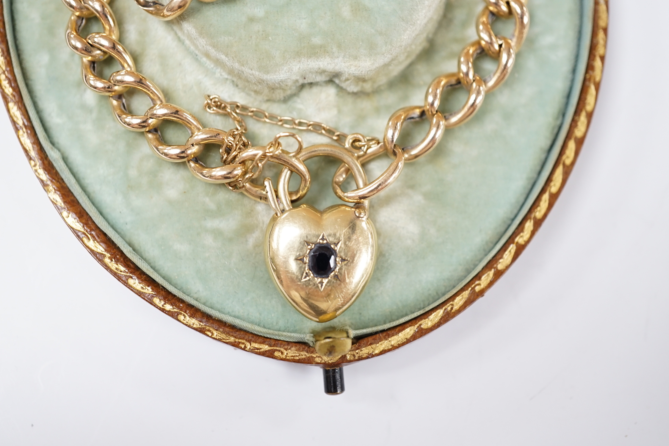 An Edwardian 15ct curblink bracelet, with sapphire set heart shaped padlock clasp, 18cm, with spare links, gross weight 13.6 grams.